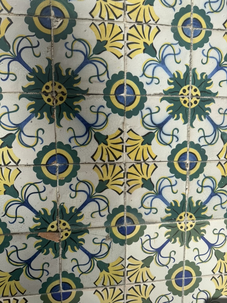 Green, yellow, and blue floral tile pattern photographed in Portugal