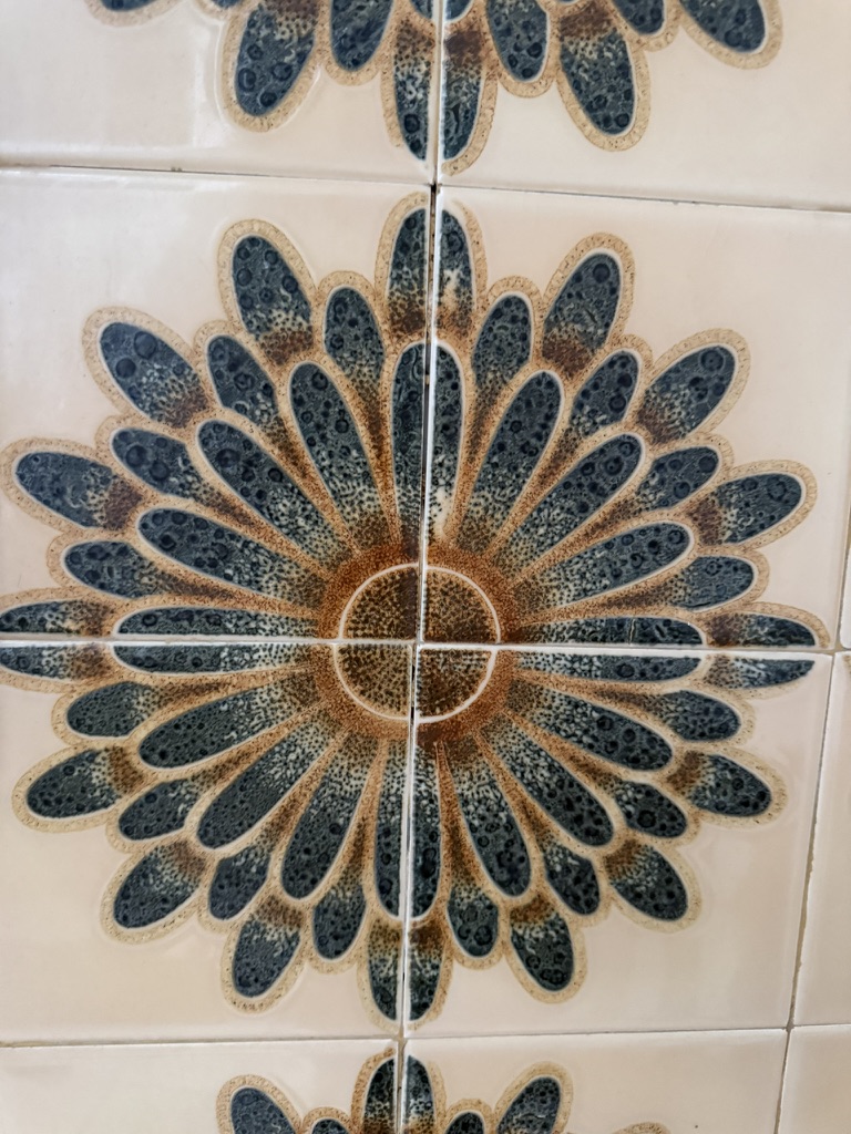 Blue and ochre ceramic rosette tile photographed in Portugal